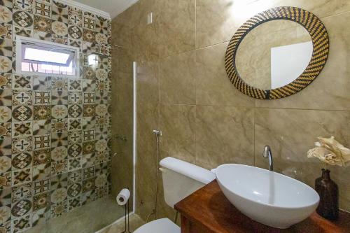 een badkamer met een wastafel, een spiegel en een toilet bij Brisas Iguazú in Puerto Iguazú