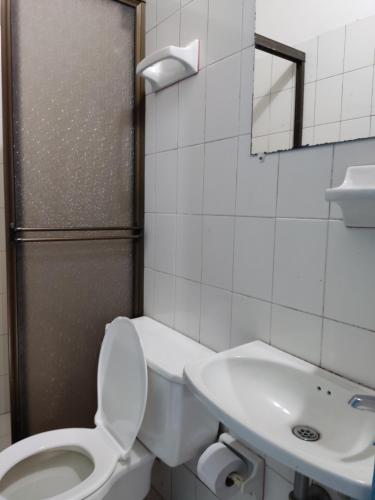 a white bathroom with a toilet and a sink at Hosteria Puerta del Nus in Cisneros