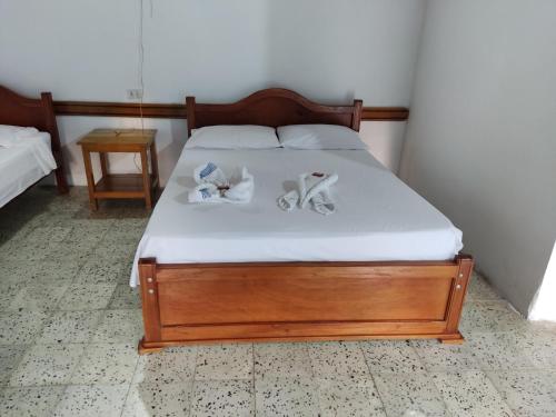 a bedroom with a bed with shoes on it at Hosteria Puerta del Nus in Cisneros