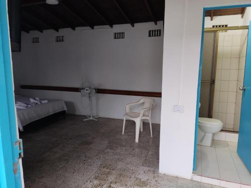 a room with a toilet and a bed in it at Hosteria Puerta del Nus in Cisneros