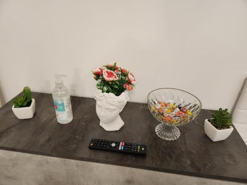 a table with a remote control and flowers in a vase at Sweet night in bari in Bari