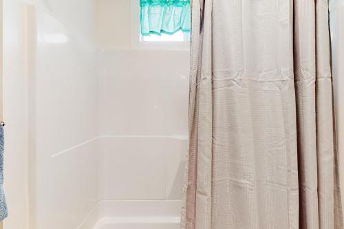 un bagno con tenda da doccia e lavandino di Cedar Street Cottage a Eureka