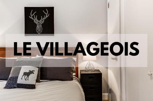 um quarto com uma cama com uma placa que lê vilarejos em Le Villageois by Gestion ELITE em Mont-Tremblant