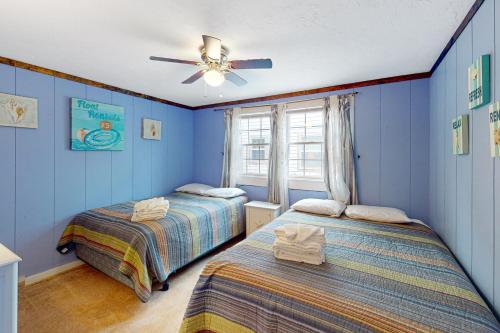 1 dormitorio azul con 2 camas y ventilador de techo en The Place to be..., en Provincetown