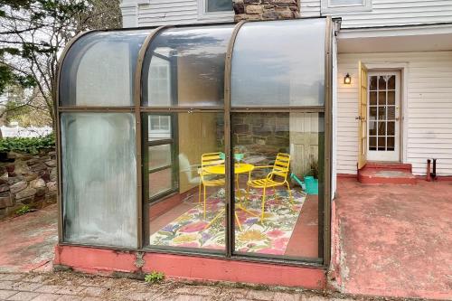 a glass house with a table and chairs in it at Maplewood Manor - Unit 1 in Colchester