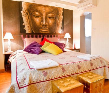 una camera da letto con un grande letto con una grande testata di L'Hermine Occitane B&B a Gratens