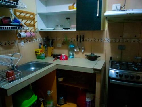a small kitchen with a sink and a stove at Passion Hostel - Barranco in Lima