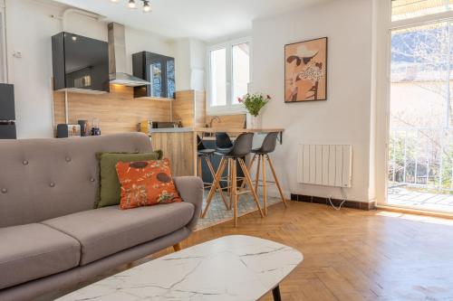 un salon avec un canapé et une table dans l'établissement Appartement T3 63m2 - L'Atypique et son Jardin de 350m2 au cœur de Digne, à Digne-Les-Bains