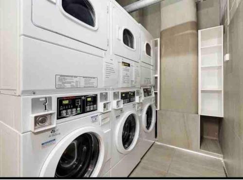 a laundry room with two washer and dryer machines at PERFECT STAY 2MIN By WALK TO THE BEACH FREE PARKING in Sydney