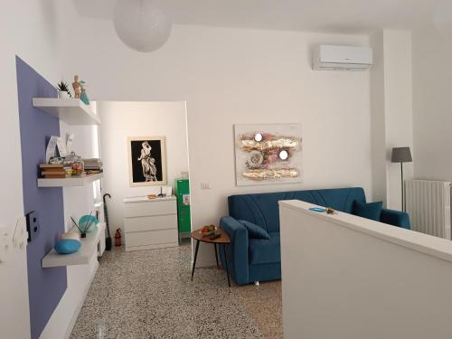 a living room with a blue couch and a table at il 64B - 10 minuti a piedi dal Policlinico San Matteo - in Pavia