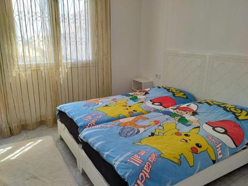 a bedroom with a bed with a pokemon comforter at magnifique maison, bien équipé in Kelibia