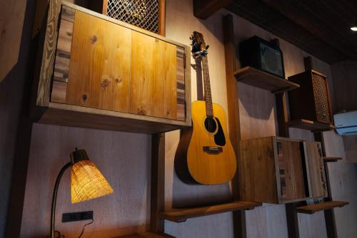 a guitar is hanging on the wall of a room at Villa Yumigahama in Minamiizu