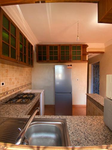 una cucina con lavandino e frigorifero di CENTRE D'ESTIVAGE IMi OUADDAR a Agadir nʼ Aït Sa