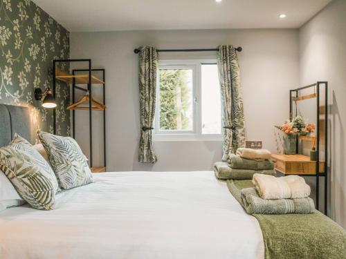 a bedroom with a large white bed and a window at Swallow Lodge - Uk42540 in Winforton