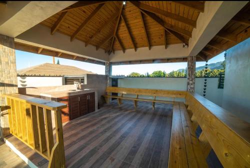 a large porch with a wooden floor and a wooden table at VillaLunaCaridad in Jarabacoa