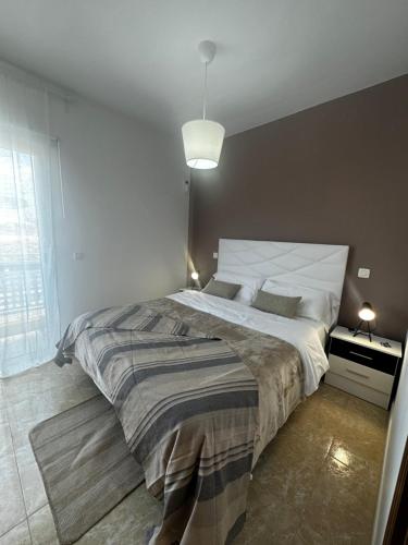 een slaapkamer met een groot bed en een groot raam bij Terraza con vistas mar/montaña in Buenavista del Norte
