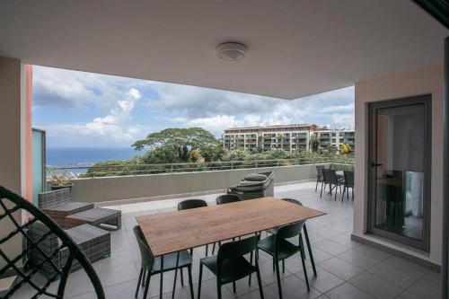 a balcony with a table and chairs and a view of the ocean at Iaorana Pamatai accomodation in Faaa