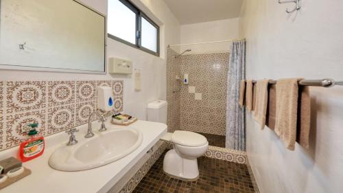 ein Bad mit einem Waschbecken, einem WC und einer Dusche in der Unterkunft Parkes Federation Motel in Parkes