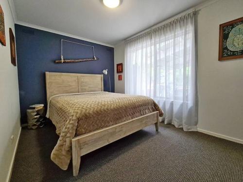 a bedroom with a bed and a large window at 'Wahroonga' home among the Gum trees in Warburton in Warburton