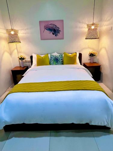 a bedroom with a large white bed with yellow pillows at HOTEL Pinc in General Santos