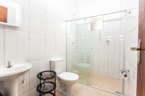ein weißes Badezimmer mit Toilette und Waschbecken in der Unterkunft Home Of The Day - Hospedagem in Cunha
