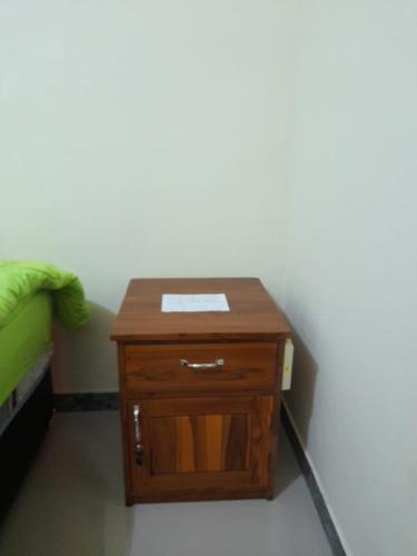uma pequena mesa de madeira num quarto ao lado de uma cama em AG HOME STAY em Labuan Bajo