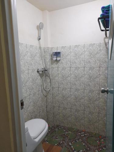 a bathroom with a shower and a toilet in it at AG HOME STAY in Labuan Bajo