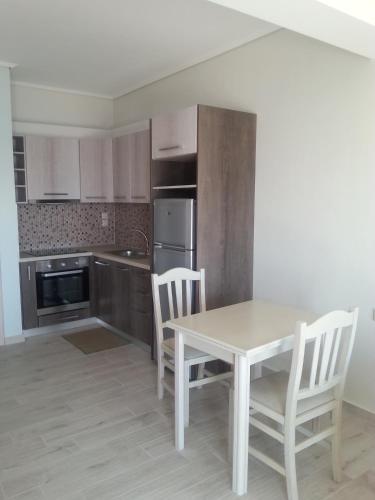 a kitchen with a table and chairs in a kitchen at Giannis Village Resort in Astakós