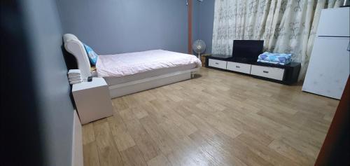 a small bedroom with a bed and a refrigerator at Green Valley in Sancheong