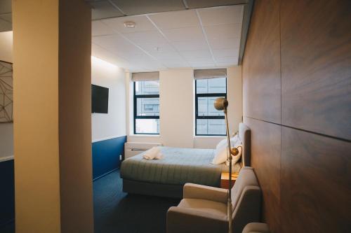 a small room with a bed and a chair at Park Hotel, Lambton Quay in Wellington