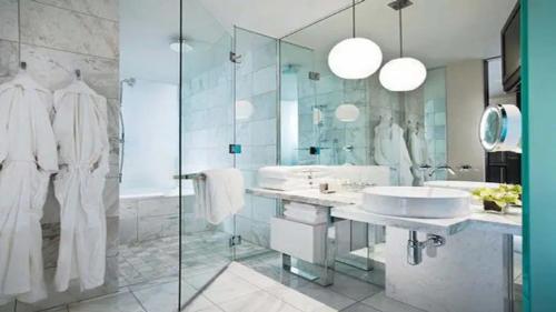 baño con 2 lavabos y ducha de cristal en Fantastic palms place with strip views 23rd floor, en Las Vegas