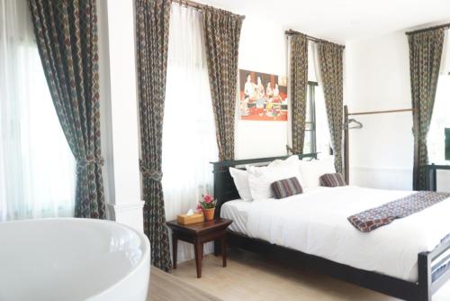 a bedroom with a bed and a bath tub at ANANTAYA CHIANGMAI BOUTIQUE HOTEL in Chiang Mai