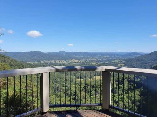 a balcony with a view of the mountains at Unwind in Woombye in Woombye