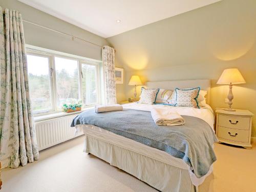 a bedroom with a bed and a window at Long Meadow in Midhurst