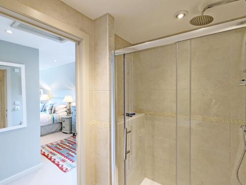 uma casa de banho com uma cabina de duche ao nível do chão ao lado de um quarto em Long Meadow em Midhurst