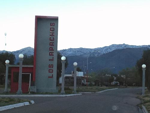 ein Schild für ein Hotel mit Bergen im Hintergrund in der Unterkunft Casa Los Lapachos in La Punta