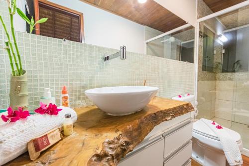 uma casa de banho com um lavatório num balcão de madeira em Vilarejo Barra Grande em Barra Grande