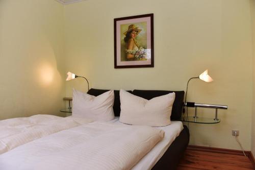 a hotel room with two beds with white pillows at Haus Seebrise in Wustrow