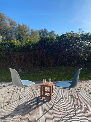 two chairs and a coffee table on a patio at Bungalow Schifferberg Lodge in Ahrenshoop
