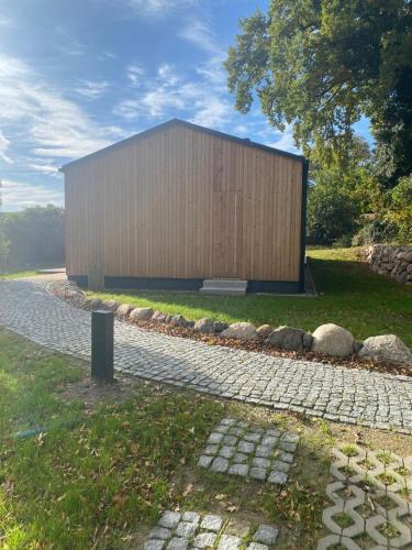 a large wooden building on the side of a road at Bungalow Schifferberg Lodge in Ahrenshoop