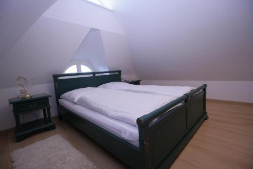 a bedroom with a bed and a table and a window at Haus Koppelweg FW-Fisch in Ahrenshoop
