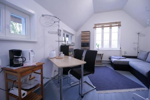 a living room with a table and chairs and a couch at Haus Koppelweg FW-Muschel in Ahrenshoop