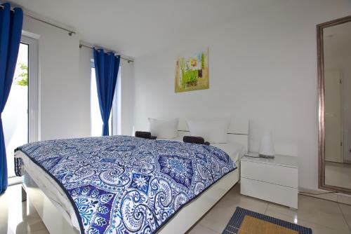 a bedroom with a bed with a blue and white blanket at Ostseetraum 04 - Aquamarin in Neuhaus