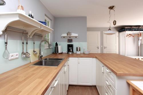 a kitchen with white cabinets and a sink at Strandnest in Wustrow