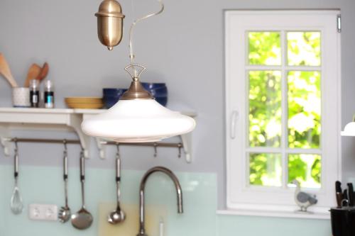 a kitchen with a sink and a light fixture at Strandnest in Wustrow