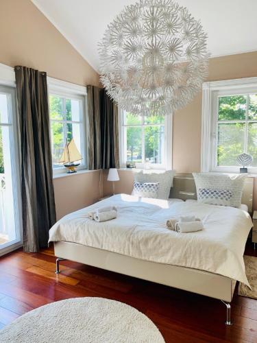 a bedroom with a large bed with a chandelier at Strandquartier 31 "Quartier 1" in Wustrow
