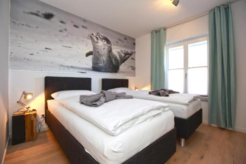 una camera con due letti con una balena sul muro di Kleine Robbe Whg1 a Wustrow