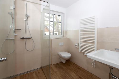 een badkamer met een douche, een toilet en een wastafel bij Haus Eichkater in Dierhagen