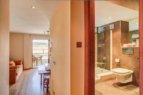 a bathroom with a toilet and a bath tub at Apartamentos Astuy in Isla