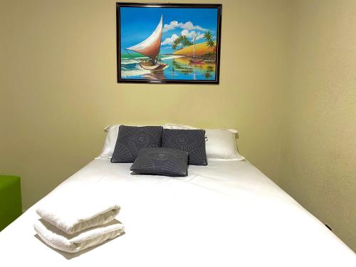 1 dormitorio con 1 cama con una foto en la pared en Casa no Centro, Home Office com ar condicionado en Aracajú